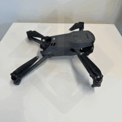 Drone replié posé sur une table blanche.