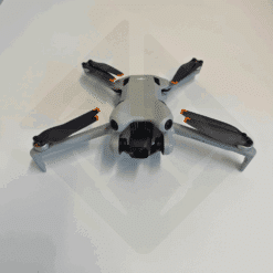 Drone gris déplié sur une surface blanche.