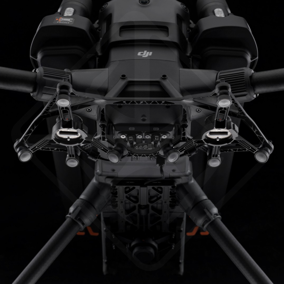 Black drone on a dark background, view from below.