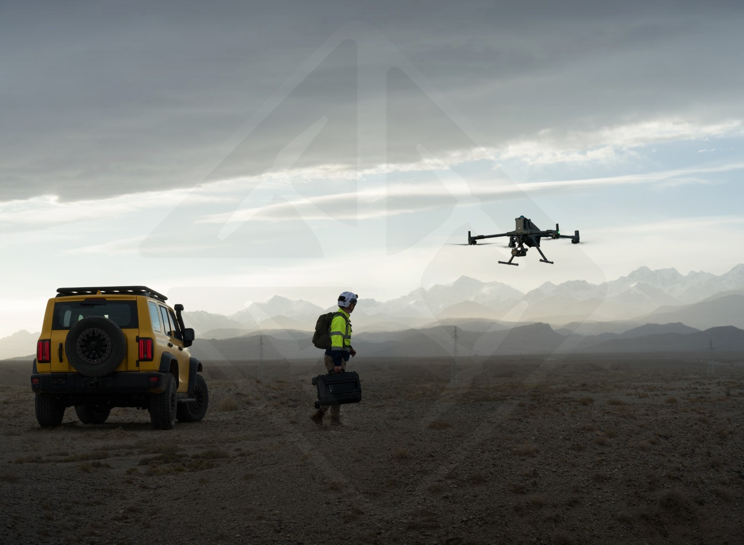 Homme préparant un drone près d'une montagne.