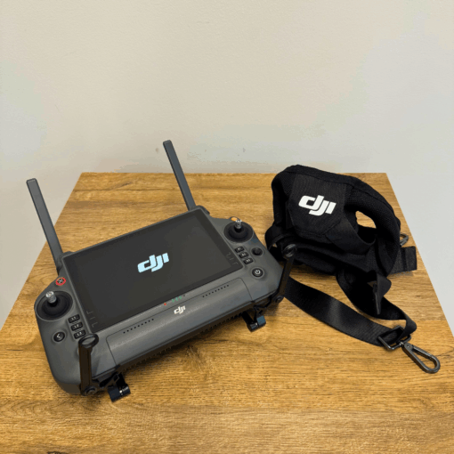 DJI remote control and strap on a wooden table.
