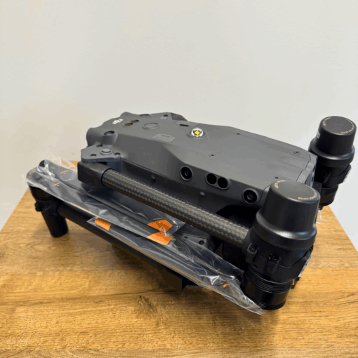 Grey drone folded on wooden table.