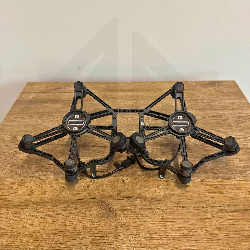 Support noir pour appareil électronique sur table en bois.