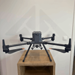 Drone noir posé sur une table en bois.