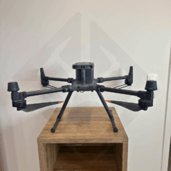 Drone noir posé sur une table en bois.