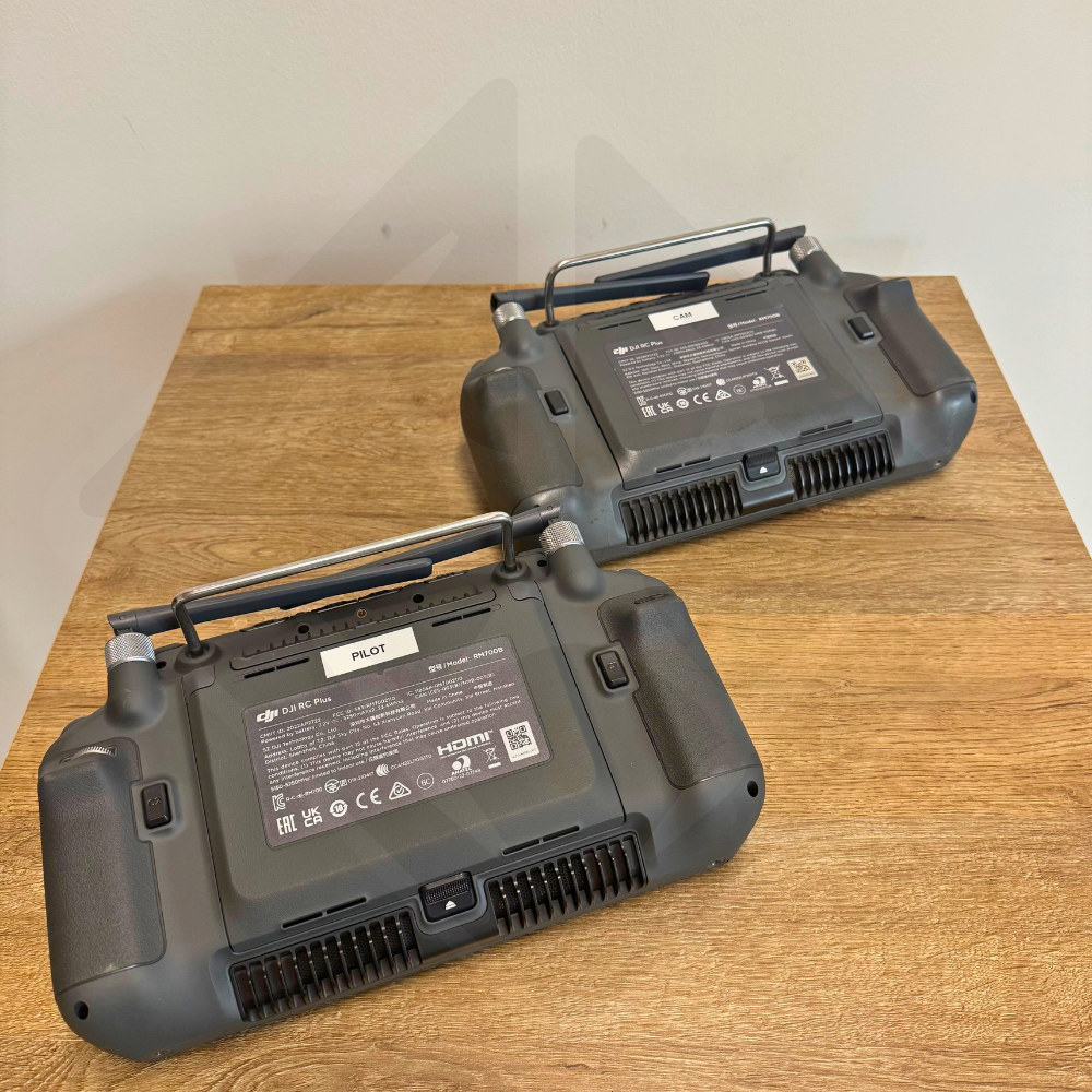 Deux télécommandes noires sur une table en bois.