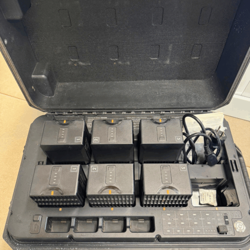 Valise avec six batteries chargées et câble électrique.