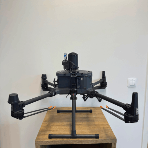Drone noir sur table en bois, quatre hélices.