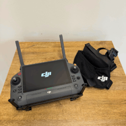 Télécommande et sac DJI sur une table en bois.