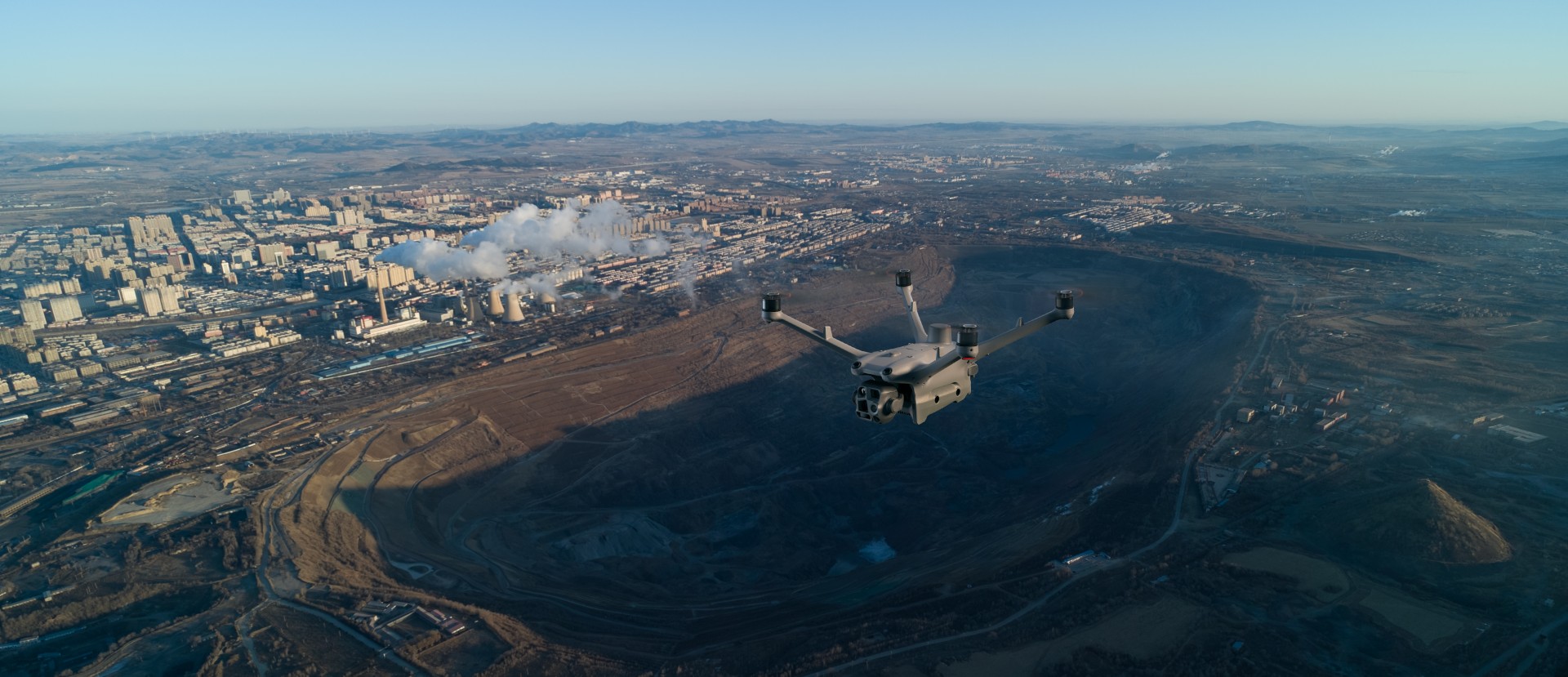 Drone die in de schemering over een industriestad vliegt.