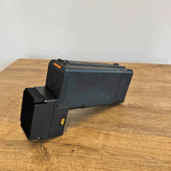 Black electronic device on wooden table.