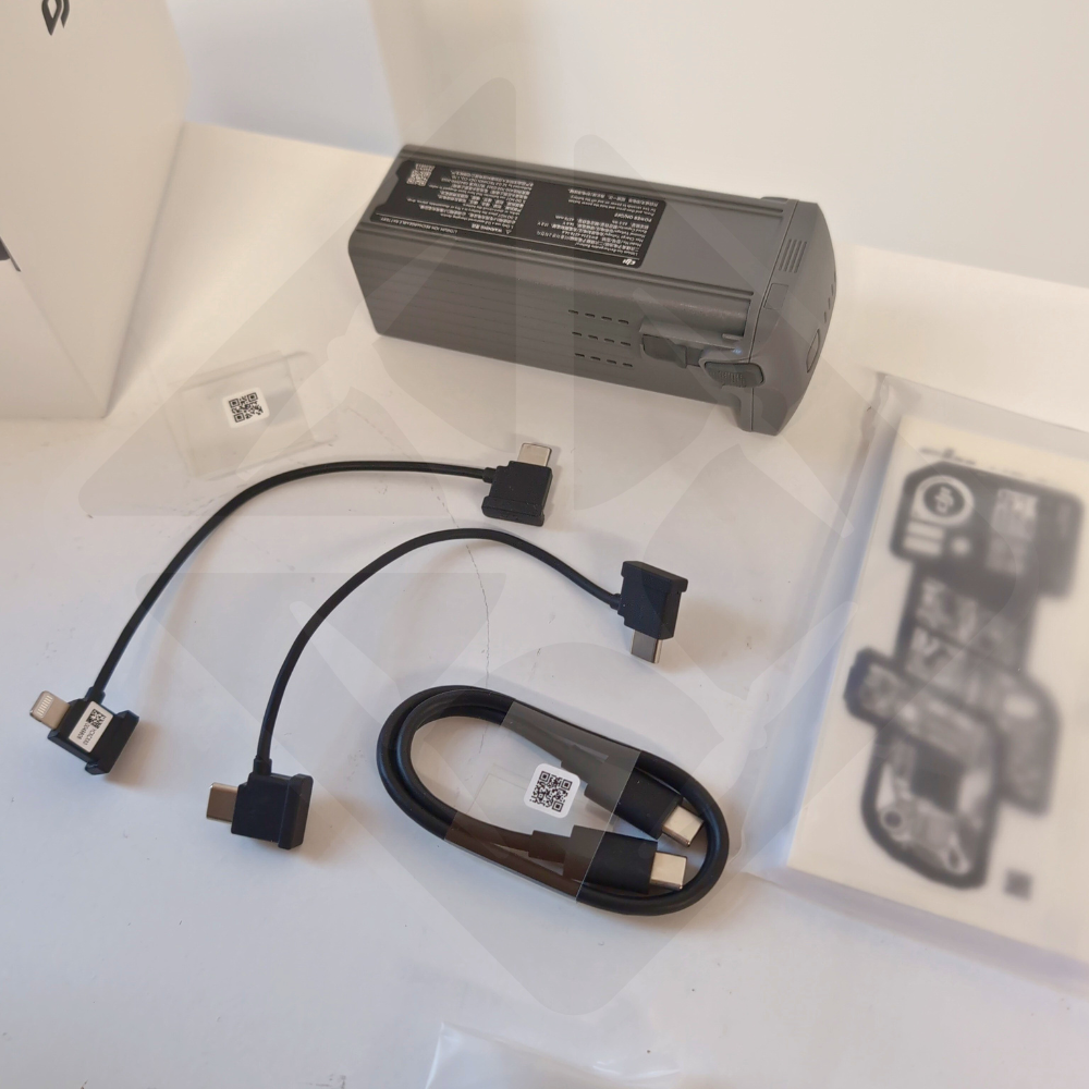 Batterie et câbles de connexion sur une table blanche.