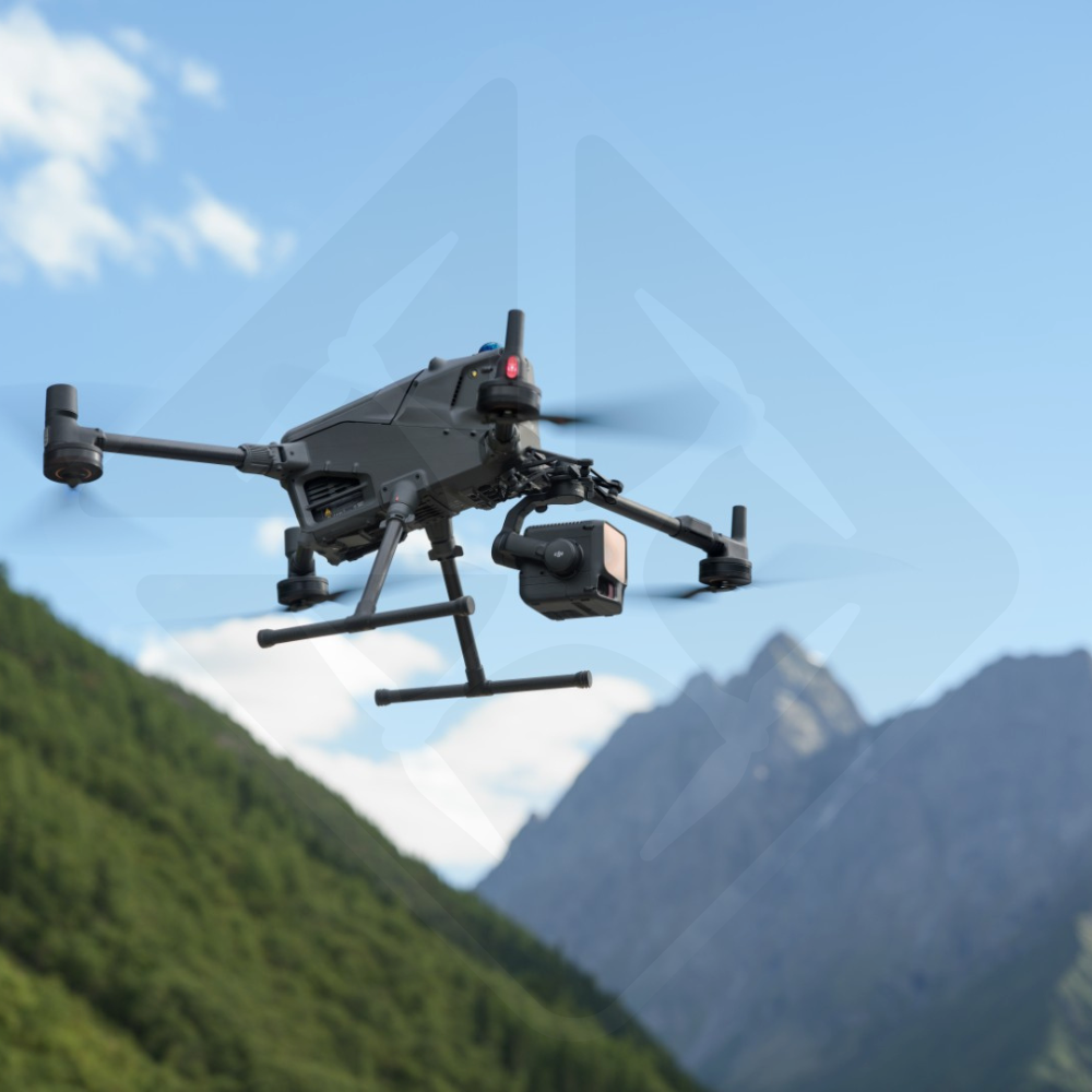 Drone flying in the mountains under blue sky.