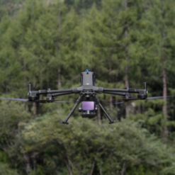 Drone flying in front of trees.