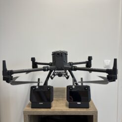 Drone avec deux télécommandes sur une table en bois.
