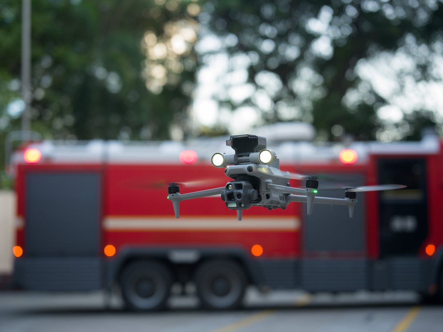 DJI Matrice 4T lors d'une intervention pompiers, projecteur allumé.